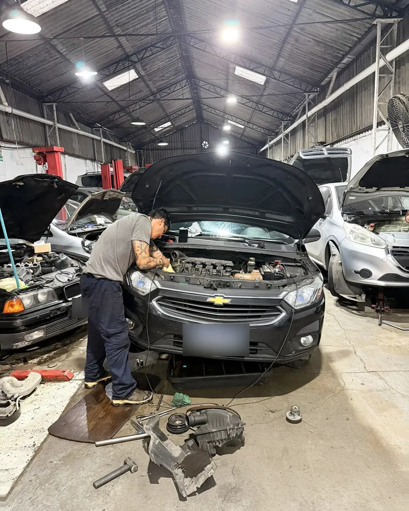 Mecânico da Cali Garage trabalhando no motor de um Chevrolet preto